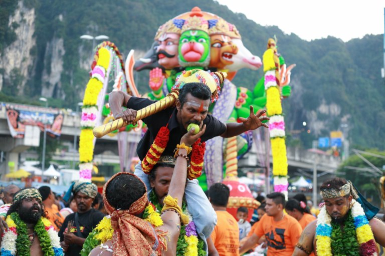 A man give an apple to a Hindu devotee as they walk towards the Batu Caves Temple during the Thaipusam festival on February 03, 2015. The Hindu festival of Thaipusam, commemorates the day when Goddess Parvati gave Lord Murugan a Vel, a divine javelin to destroy the evil demon Soorapadman. photo Aizzat Nordin