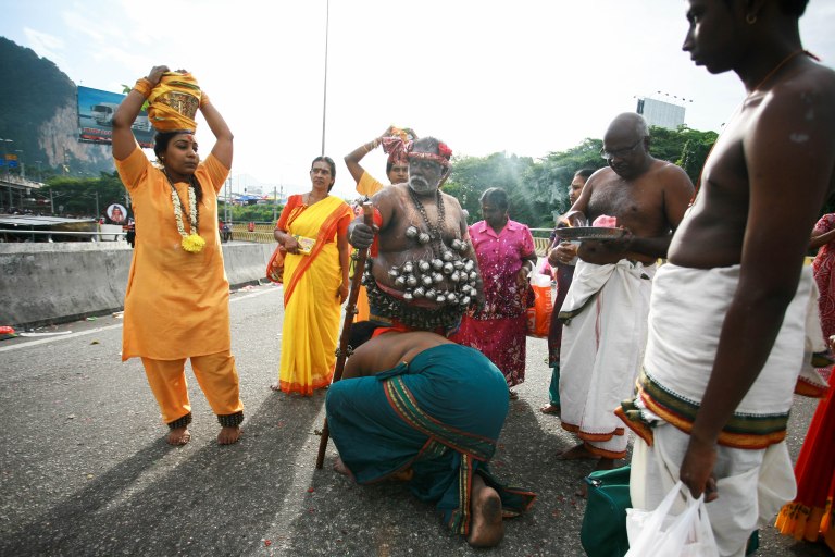 A family member of a Hindu devotee help him with his religious cloth as they walk towards the Batu Caves Temple during the Thaipusam festival on February 03, 2015. The Hindu festival of Thaipusam, commemorates the day when Goddess Parvati gave Lord Murugan a Vel, a divine javelin to destroy the evil demon Soorapadman. photo Aizzat Nordin