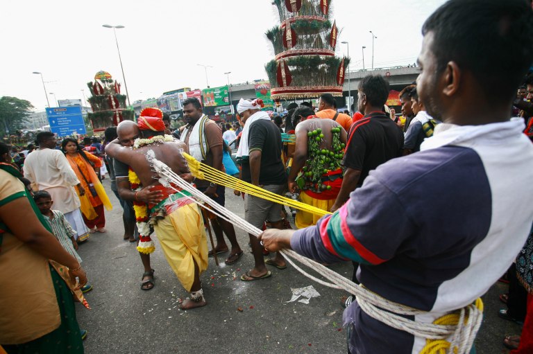 A family member of a Hindu devotee comfort him as he makes his way towards the Batu Caves Temple with his back are pierced with hooks during the Thaipusam festival on February 03, 2015. The Hindu festival of Thaipusam, commemorates the day when Goddess Parvati gave Lord Murugan a Vel, a divine javelin to destroy the evil demon Soorapadman. photo Aizzat Nordin